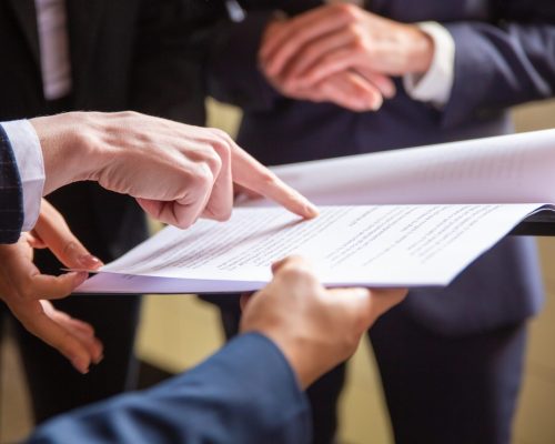 Cropped view of businesswomen reading document. Closeup shot of female finger pointing at page. Business concept