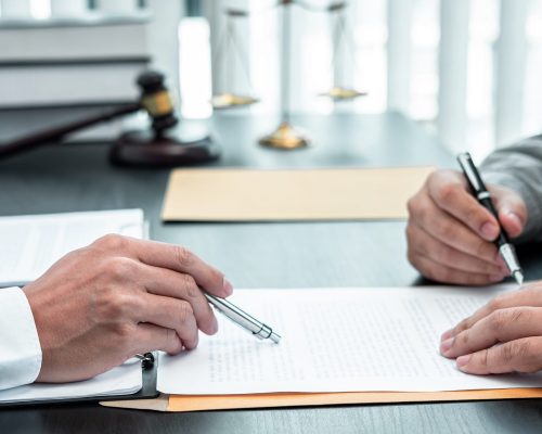 Male lawyer discussing negotiation legal case with client meeting with document contact in courtroom, law and justice concept.